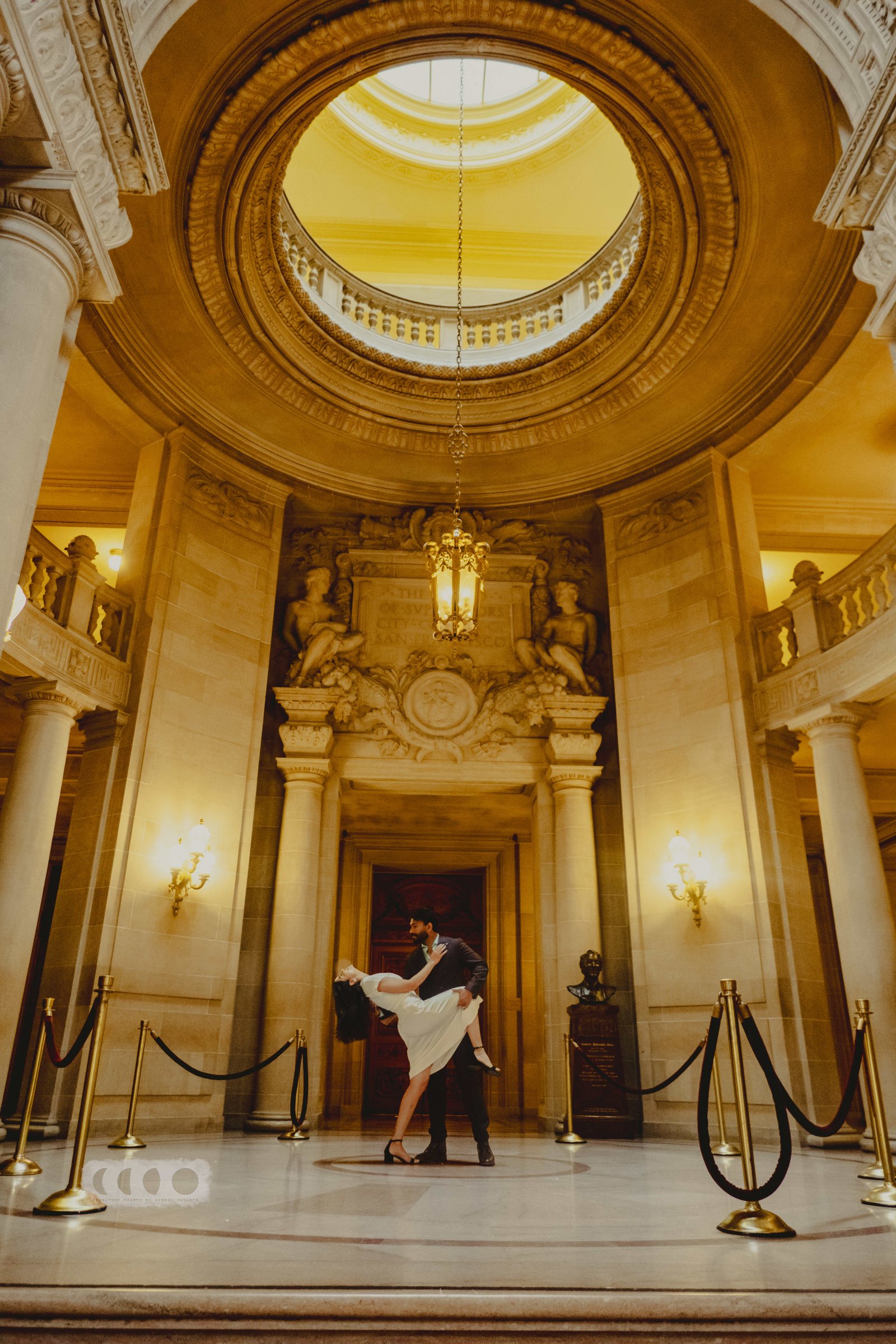 A couple dancing beneath an ornate domed ceiling